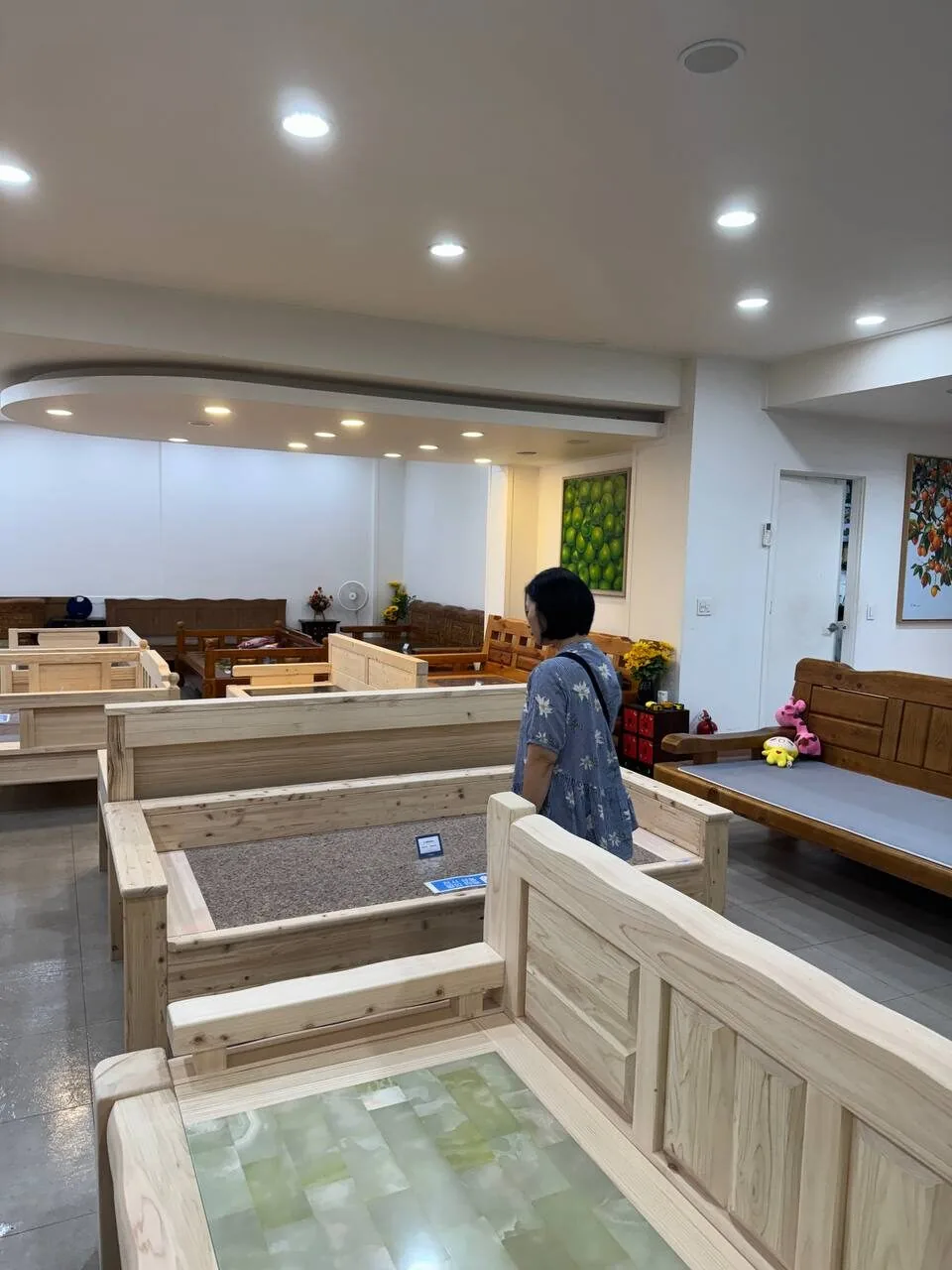 매장에 전시된 원목 프레임 침대들을 둘러보는 모습